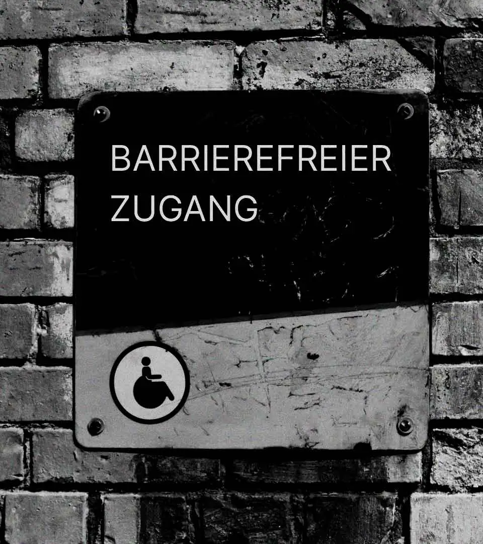 Schild an einer Ziegelwand mit dem Hinweis auf barrierefreien Zugang – eine visuelle Darstellung von Barrierefreiheit.